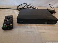 Front view of Sony BDP-S1700 player with remote and power cable