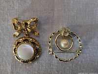 Front view of both brooches showing design and stones