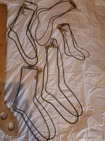 Six wire sock hangers of two lengths displayed on white background