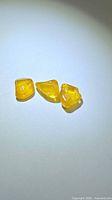 three yellow sapphire crystals on neutral background