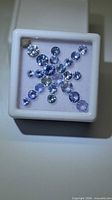 Top view of loose round tanzanite gemstones arranged in display box