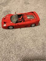 Left side view of red Ferrari F50 diecast model showing open-top and interior
