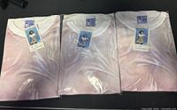 Front view of three sealed Wet Tees T-shirts