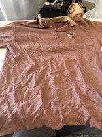 Full view of maroon patterned polo shirt laid flat