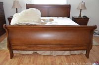 Front view of assembled sleigh bed with mattress and bedding
