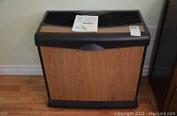 Front view of humidifier with wood grain panel and instruction manual on top.