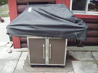 Covered grill front view showing cabinet doors and protective cover