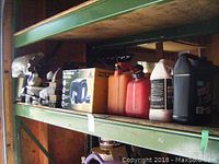 Full shelf view showing assorted items including boxed winch, gas cans, and oil containers