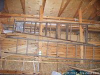 Two wooden ladders leaning against wall framing