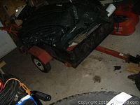 Front and side view of steel utility trailer loaded with green tarp