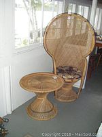 Photo showing the high-backed bamboo chair and matching table together in a room setting near a window.