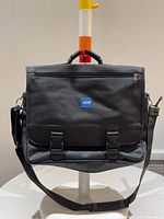 Front view of bag showing EDS logo, flap, buckles, strap