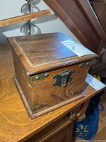 Front view of wooden box showing lock clasp and brass hardware