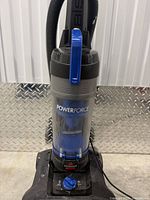 Front view of Bissell PowerForce upright vacuum showing dust canister, hose, and branding