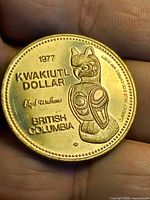 Reverse side showing 1977 date, Kwakiutl Dollar text and totem design