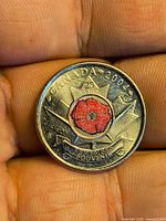 Reverse of 2004 Canada 25-cent coin showing red poppy design and inscription