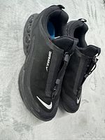 Top and side view of both shoes showing zippers, Swoosh, Air units