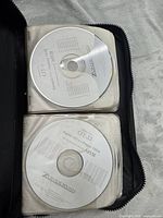 Open case showing two pages of white Zondervan NIV Audio Bible CDs in plastic sleeves