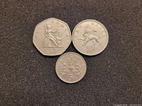 Obverse sides showing Britannia, lion, and crowned thistle designs of the 50, 10, 5 coins