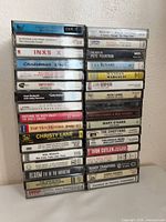 Two-column stack of 34 cassette tapes showing spines and titles