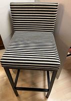 Front view of bar stool showing striped upholstery and metal frame