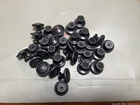Pile of approximately 35 oil-rubbed bronze cabinet knobs on surface