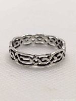 Angled view of the sterling silver Celtic knot ring showing openwork pattern around the band