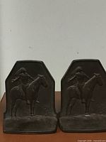 Front view of both brass bookends with Native American rider motif