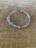 Full view of silver adjustable bangle bracelet with decorative beads