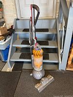 Full view of Dyson DC42 Animal vacuum standing upright with cleaner head detached