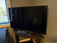 Front view of Sony 55" TV on stand with remote