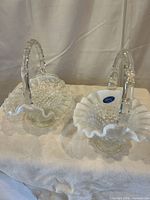 Pair of Fenton hobnail milk glass baskets with clear handles and ruffled rims