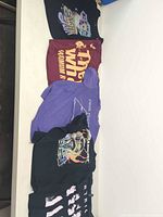 Five folded T-shirts displayed on table