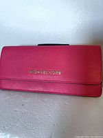Front view showing pink saffiano leather and gold logo