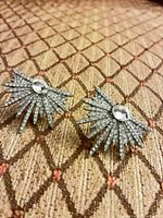 Front view of both earrings showing rhinestone sunburst design and central stones