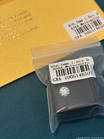 Moissanite in box with label showing specifications and GRA envelope