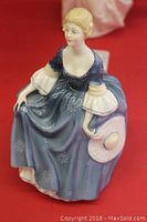Front and side views of Royal Doulton Hilary HN 2335 figurine in blue dress holding a white hat