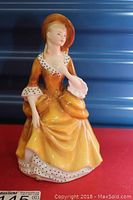 Front view of Royal Doulton figurine Sandra wearing yellow dress and brown hat