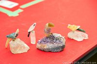 Four quartz bird figurines displayed on red surface showing overall set and base details.