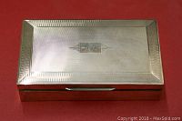 Closed box top view showing engine-turned finish and HOC monogram on lid