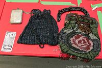 All three items displayed on red surface: silver card case, black bead bag, floral bead bag with frame and chain