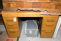 Front view showing desk with six drawers and minor scuffs.