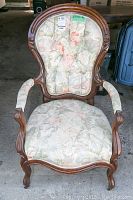 Front view of Victorian gentleman's chair showing carved wooden frame and floral fabric upholstery.