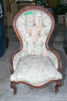 Full front view of Victorian ladies chair showing carved mahogany frame and floral upholstery with button tufting on the backrest.