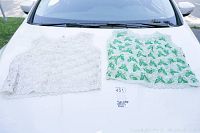 Photo showing two vintage beaded evening tops laid flat on white surface, one with white bead and sequin pattern, the other with green bead and sequin pattern.