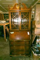 Full view of the mahogany secretary desk cabinet with closed drop-front and glass doors with mullions.