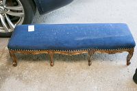 Full-length front view of bench showing blue upholstered top and carved legs