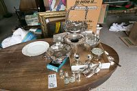 Overall shot of all silver-plate and sterling serving items on wooden table