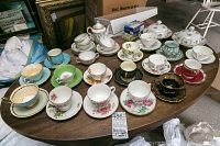 Full lot view showing multiple bone china cups and saucers arranged on table