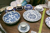 Wooden table with nine antique/vintage porcelain items including Coalport, Aynsley, Staffordshire cups and saucers, blue and white floral decorative plates and bowl.